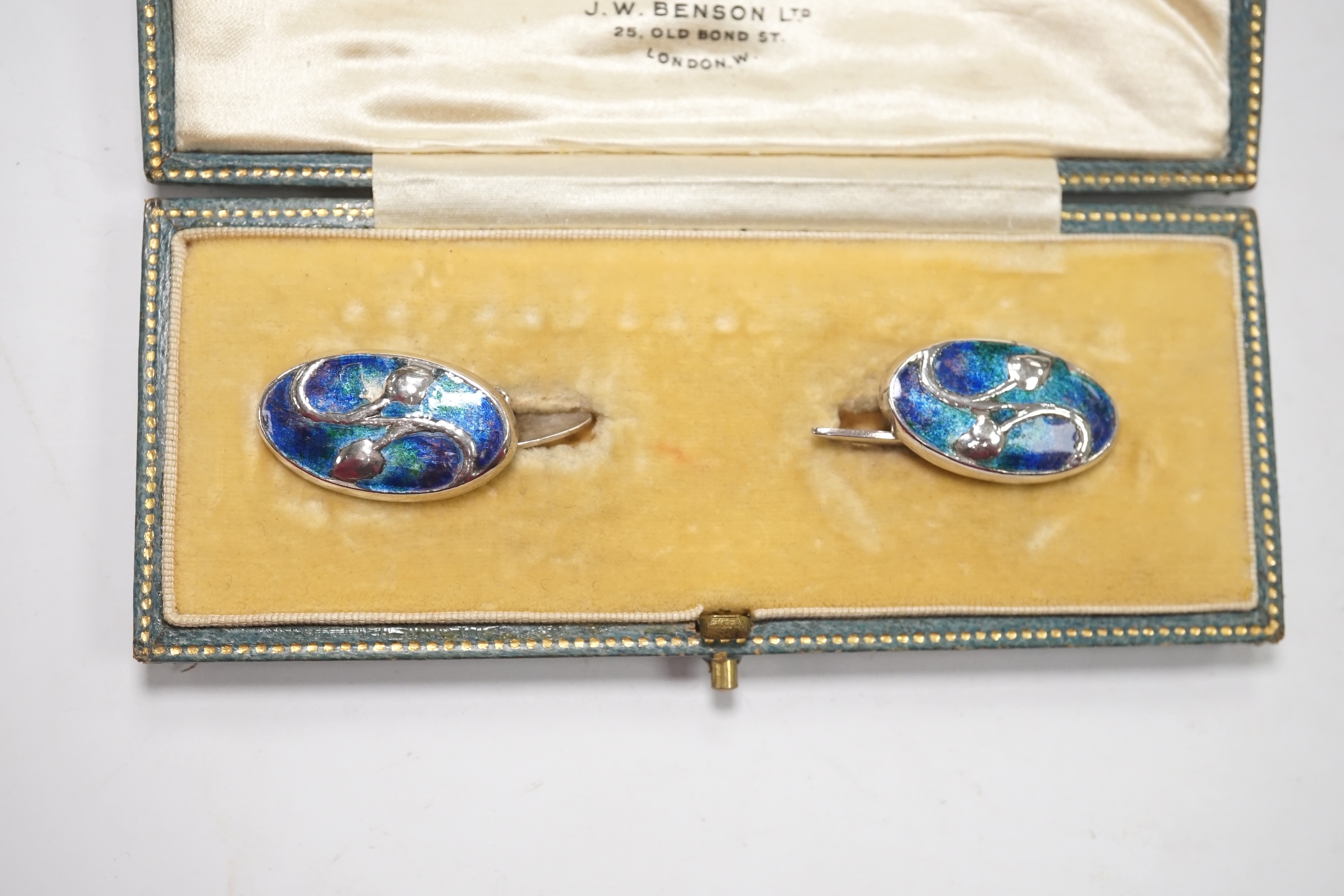 A pair of Edwardian Art Nouveau silver and enamel oval cufflinks, by Liberty & Co Ltd, 23mm, together with a garnet set bar brooch and a Hunt & Roskell box. Condition - poor to fair